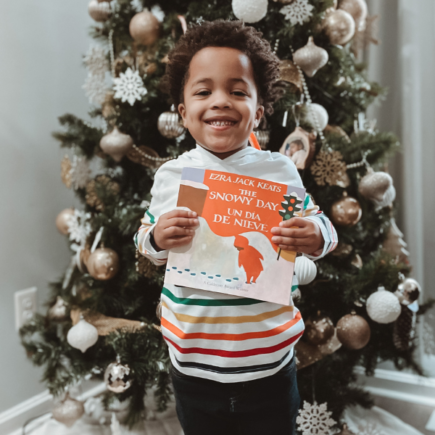 Deuce Harrison holding a Diverse Christmas Children's Book - The Snowy Day