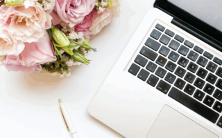 Computer pictured next to a bouquet of flowers