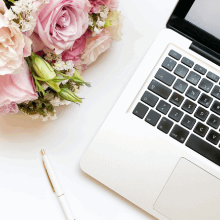 Computer pictured next to a bouquet of flowers