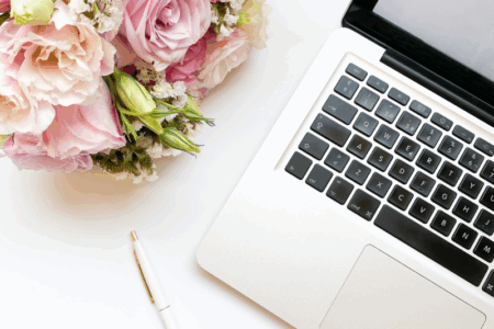 Computer pictured next to a bouquet of flowers